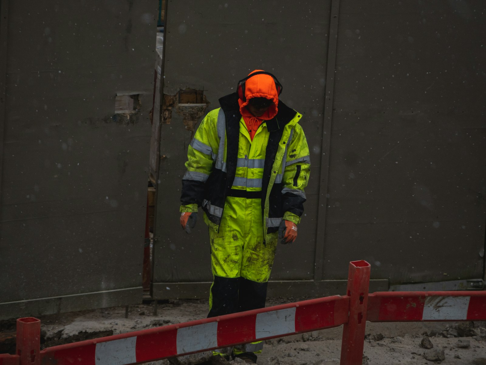 Construction worker on site in branded hi-vis jacket and waterproof bib trousers