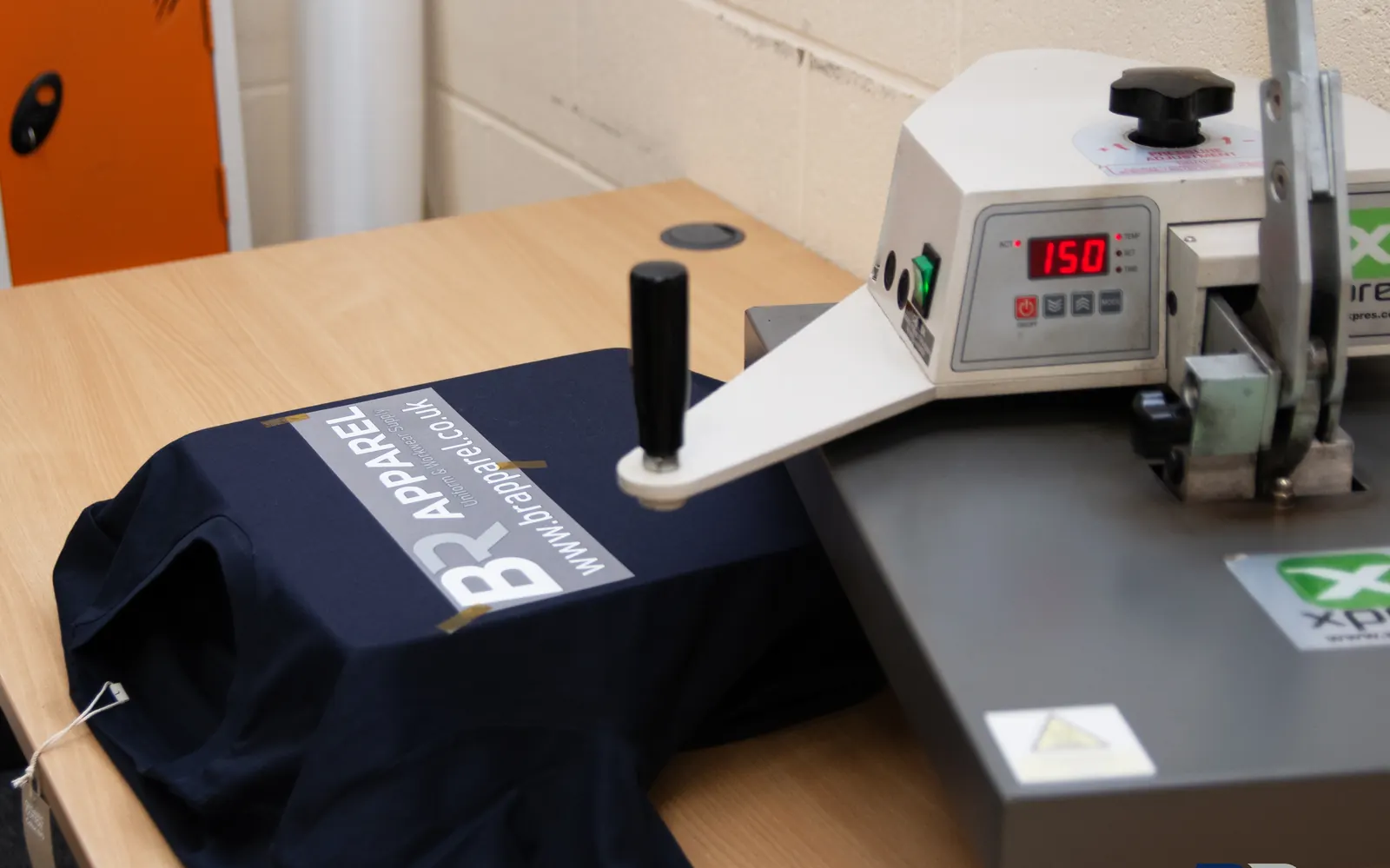 Heat press applying a printed transfer to a garment at BR Apparel in Bradford