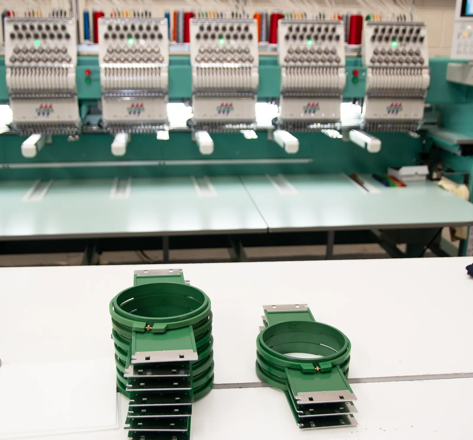 Embroidery hoops and the approved garment spec sheet for a Leeds uniform run at BR Apparel