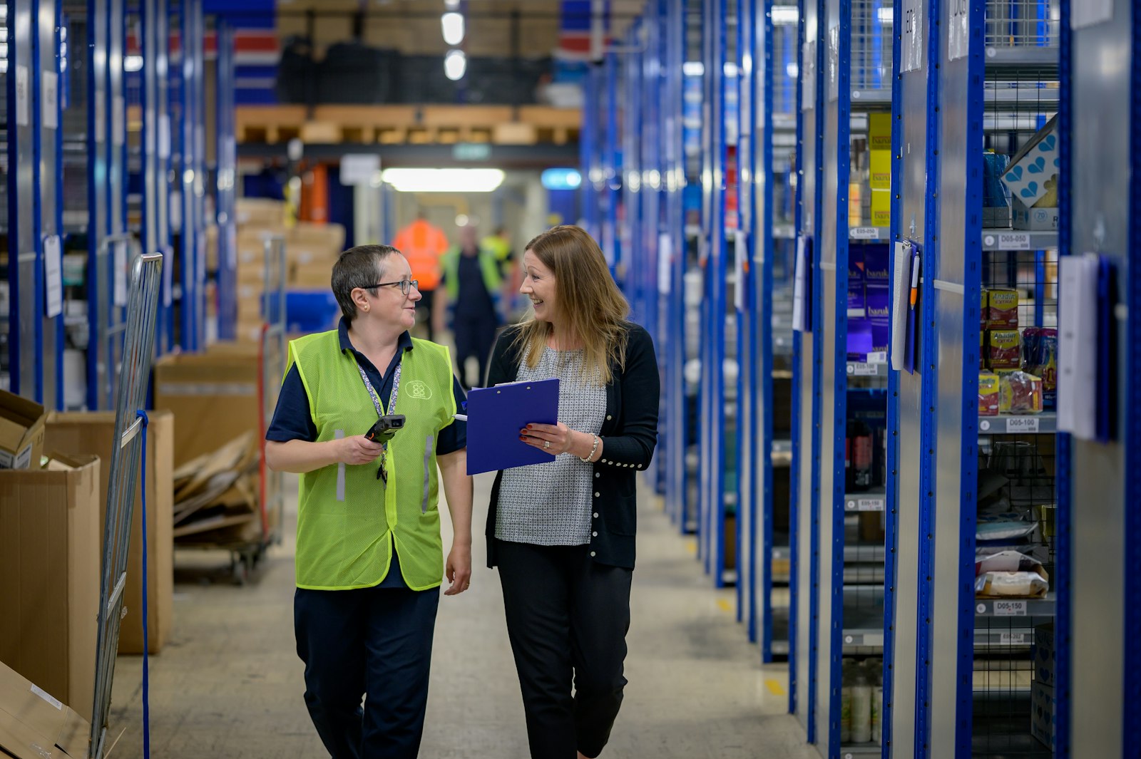 Warehouse supervisor and floor team walking the aisle of a Bradford distribution centre