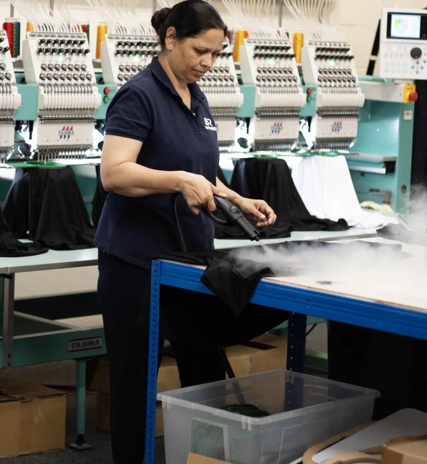 BR Apparel operator handling a branded garment on the machine line in Bradford